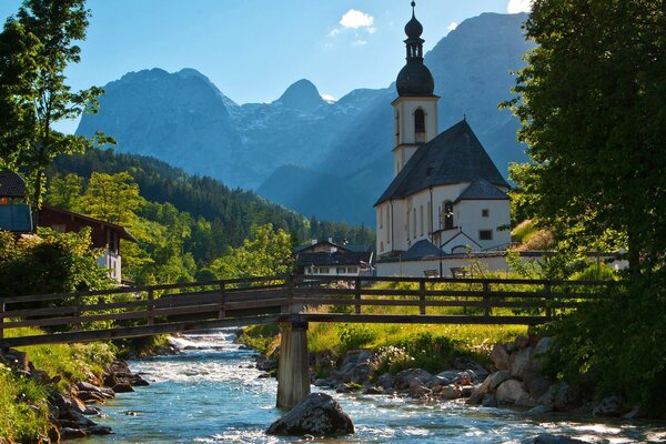 Bridge over the river among trees, mountains, churches