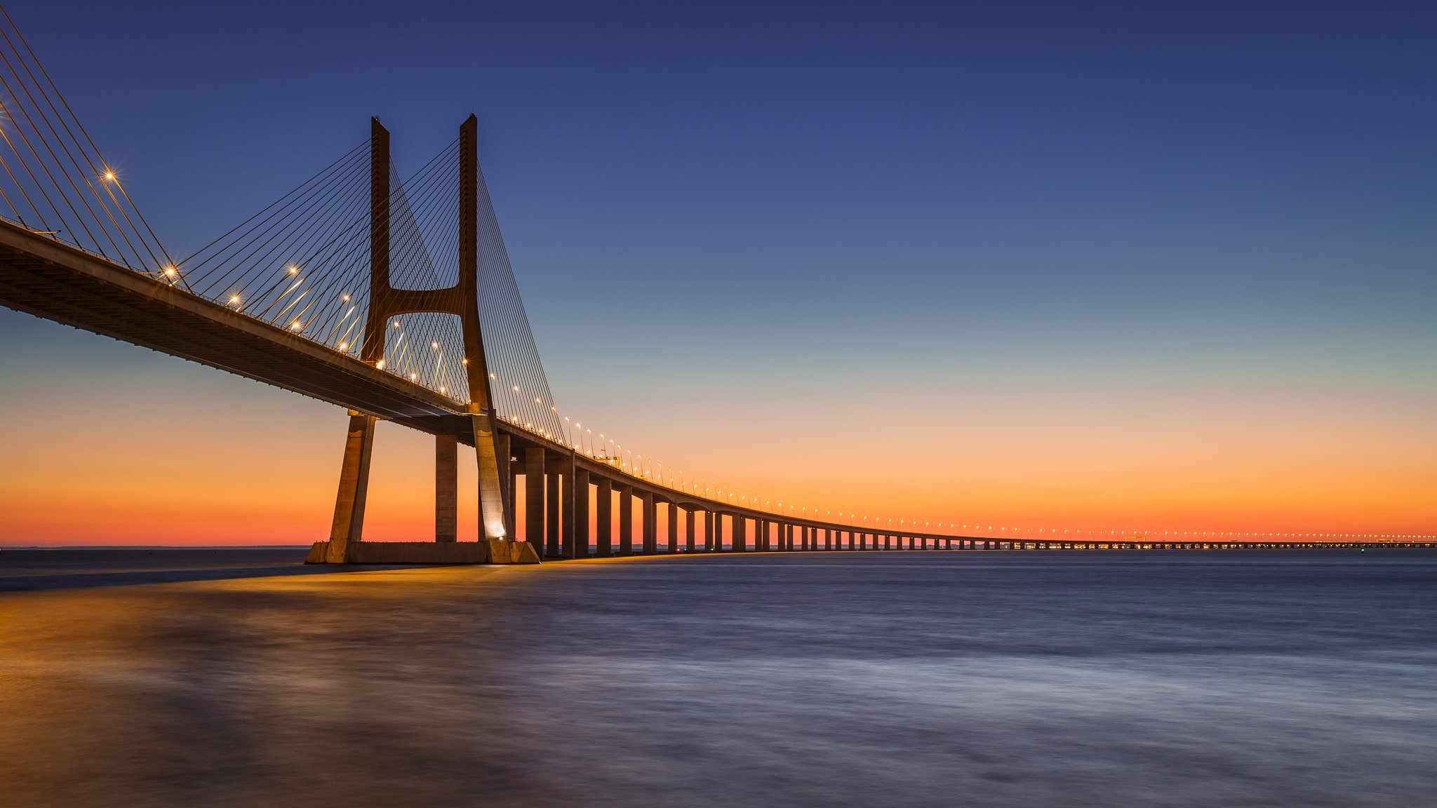 portogallo lisbona fiume tajo tago ponte vasco da gama lanterne illuminazione sera arancione tramonto blu cielo