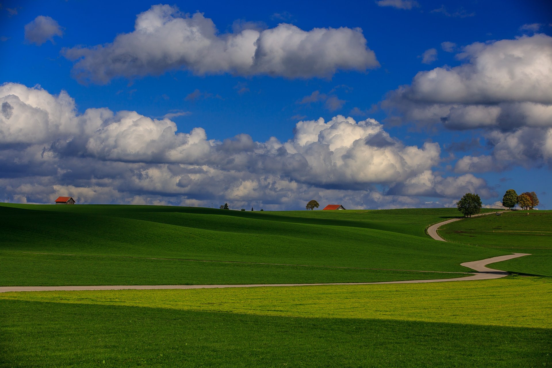 ciel nuages collines champ herbe route arbres maisons