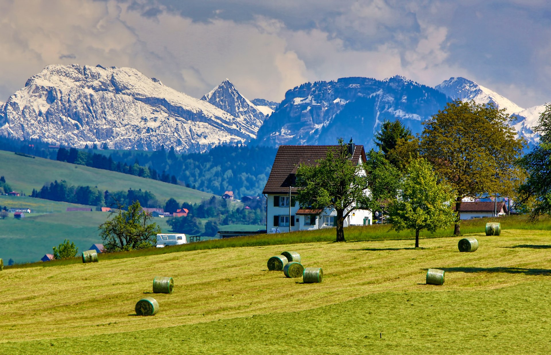 ciel nuages montagnes neige maison chalet herbe arbres champ