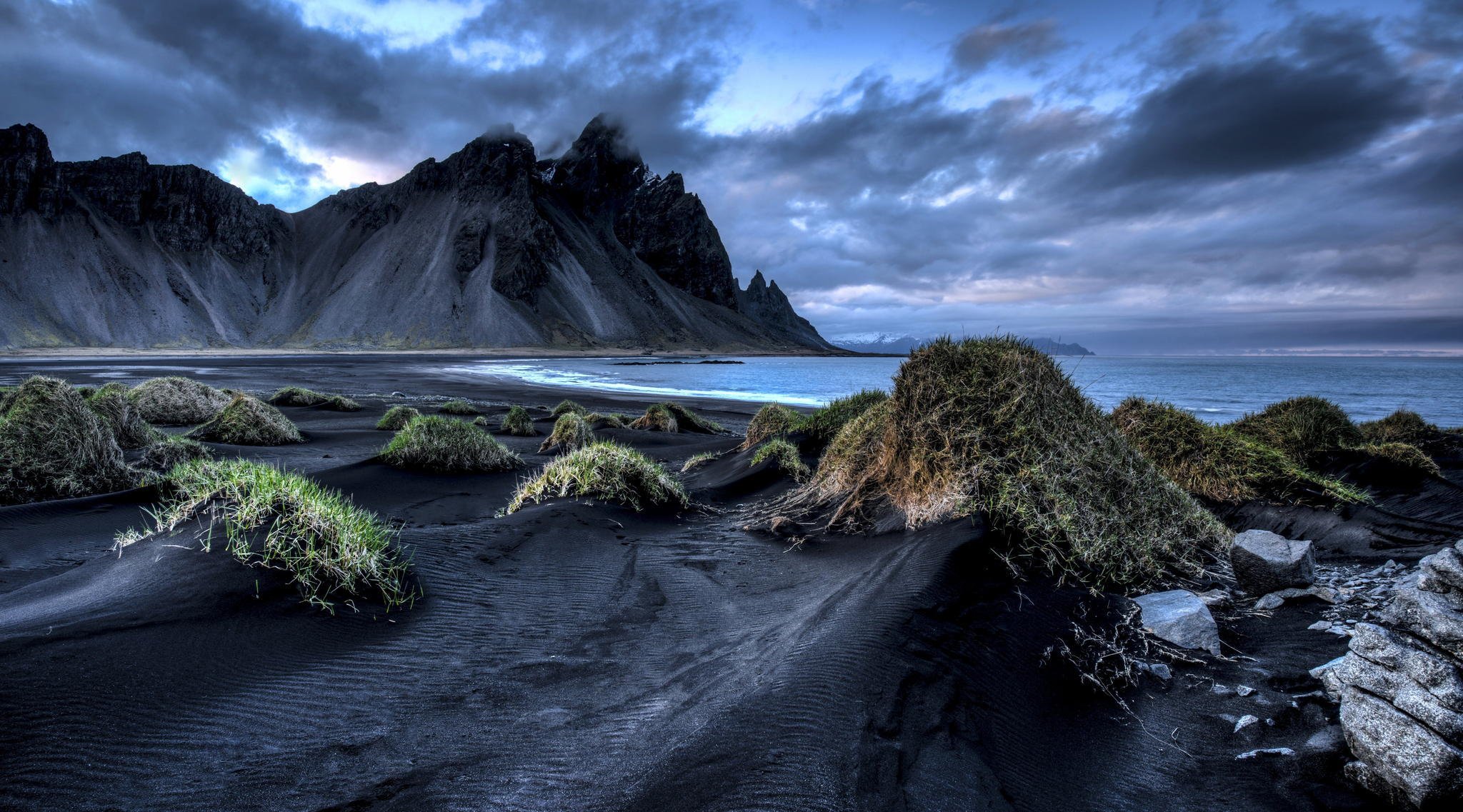 iceland vestrahorn stockksness mountain black sand sea clouds grass beach