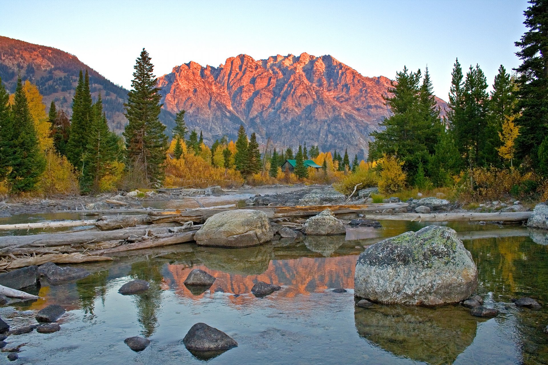 grand teton national park wyoming stati uniti d america montagne lago rocce riflessione alberi abete rosso cielo tramonto lodge autunno