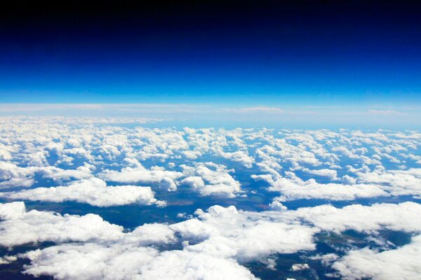 Blick aus dem Flugzeug unter weißen Wolken