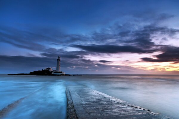 Coucher de soleil sur la mer et le phare au loin