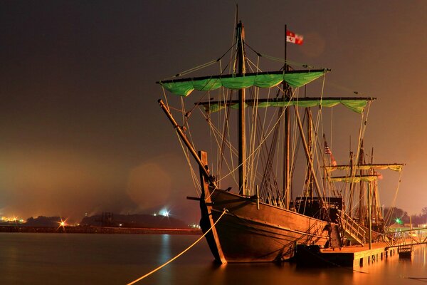 A ship at sea at night near the pier