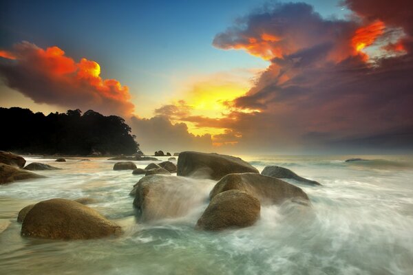 Sonnenuntergang vor dem Hintergrund des Meeres und der Steine