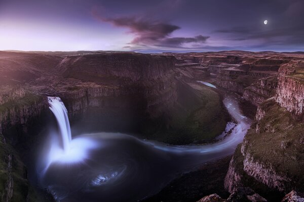 Wasserfall in einer Schlucht unter einem lila Himmel