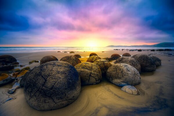 Валуны, лежащие на песке, встречают восход