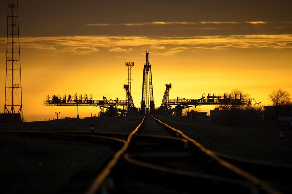 El ferrocarril en el puerto espacial se va al cielo al atardecer