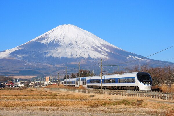 Góra Fujiyama w Japonii. Pociąg i domy na tle góry. Podróż