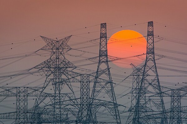 Power lines on the background of a bright red sunset