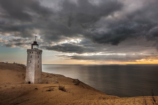 Ein einsamer Leuchtturm steht am Sandstrand des Meeres