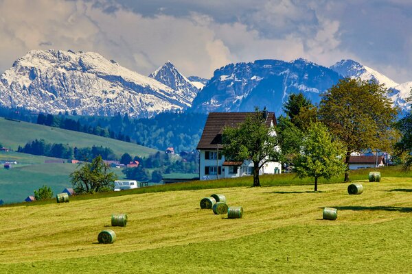 Cottage in a field beyond the mountains