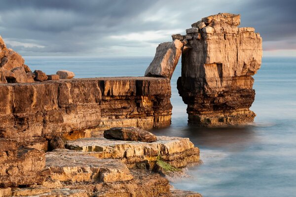 A landscape with a sea cliff and a gloomy sky