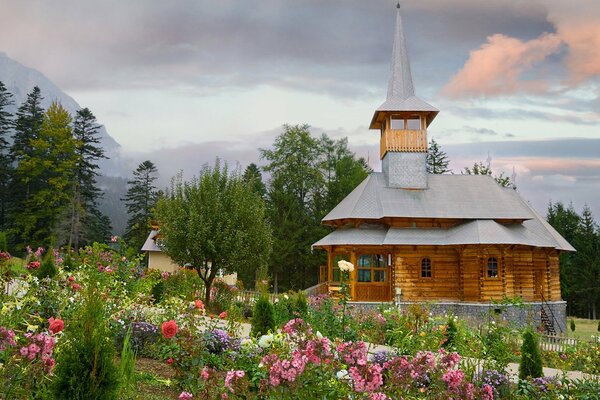 Holzhaus mit Blumenbeeten im Sommer