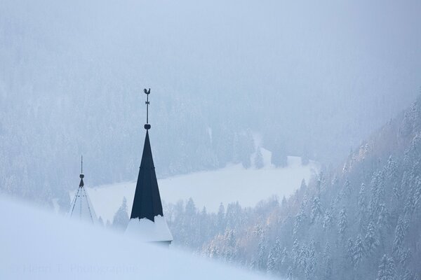 Dachdecker mit Wetterfahne im Winternebel in Frankreich