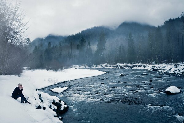 Chica en la orilla del lago de hielo de invierno