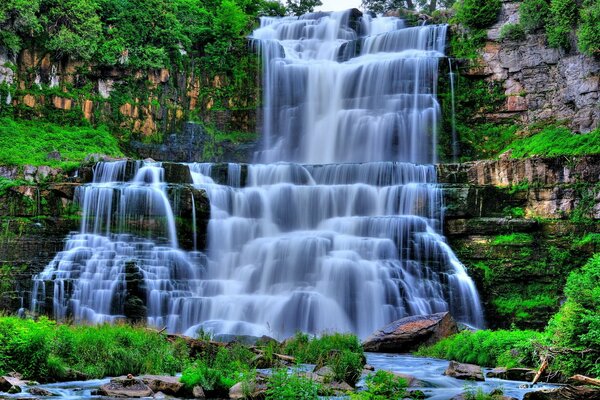 Wasserfallschwellen auf Steinen mit Gras