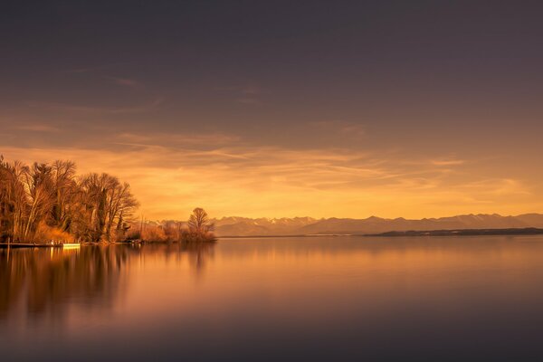 The last rays of the sun of the outgoing day illuminated the house on the lake shore