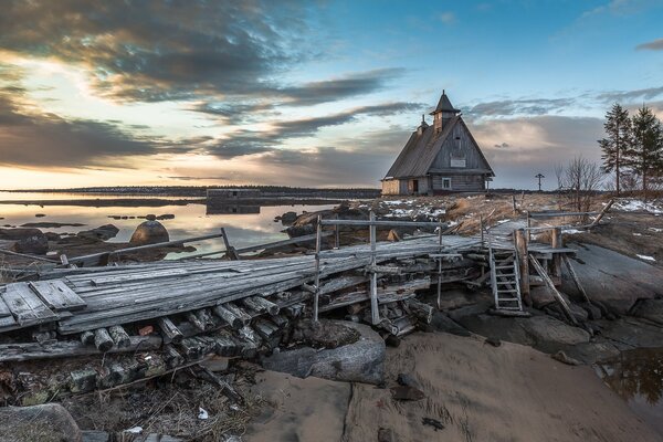 Iglesia de madera. Puente de madera. Puesta de sol en el río