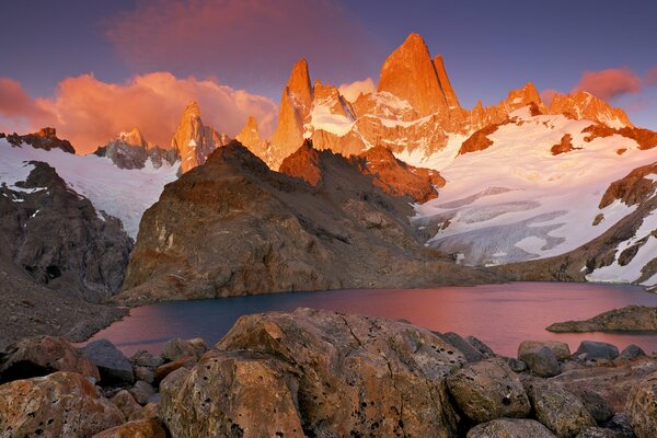 Montagnes avec de la neige autour du lac. Coucher du soleil