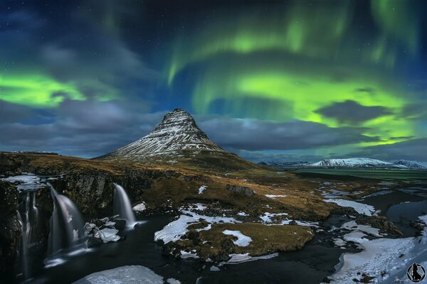 Islandia. Rocas y cascada . Aurora boreal