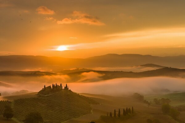 Fog covering the hilly plain in the setting sun