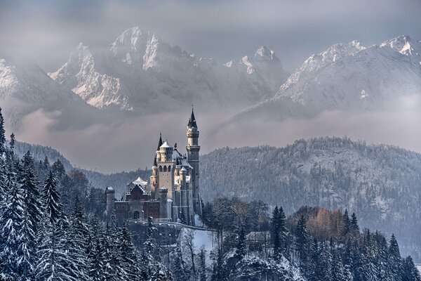 Schloss Neuschwanstein unter Schnee im Hintergrund der Berge in Bayern