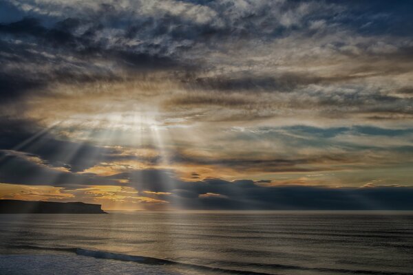 The sun s rays break through the rainy clouds