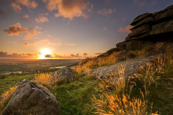 A very beautiful sunset in a field on the background of a mountain