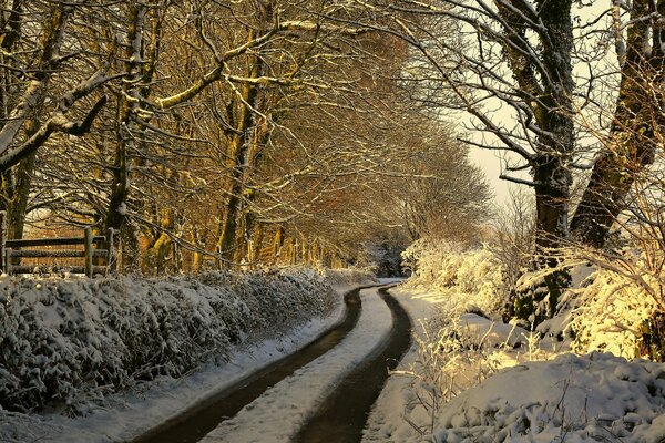 Die Straße ist im Morgengrauen mit dem ersten Schnee übersät