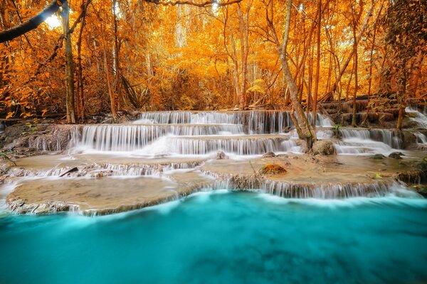 Wasserfall im Herbstwald am blauen See