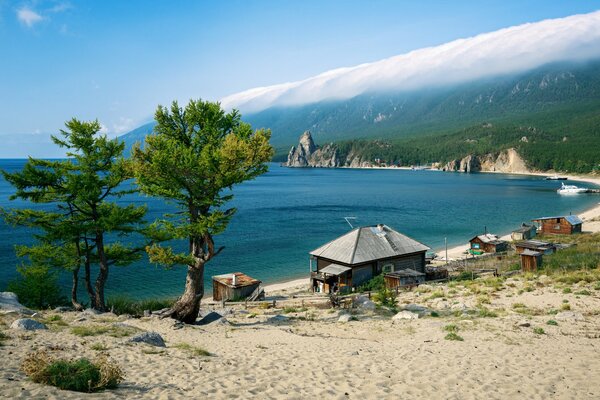 Die Küste des Baikalsees. Holzhäuser, Bäume, Tal
