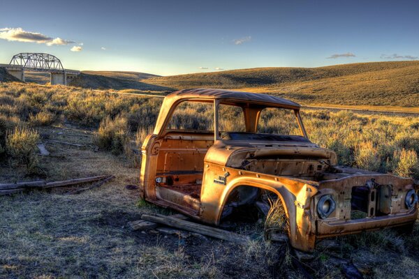 Altes Auto im Feld bei Sonnenuntergang