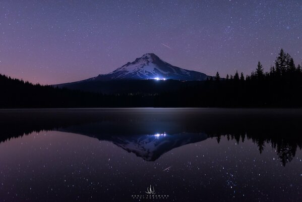 Das Leuchten der Sterne am Fuße eines Berges in Oregon, USA. Faszinierende Bäume, ein vom Fotografen aufgenommener See erzeugen eine mystische Stimmung