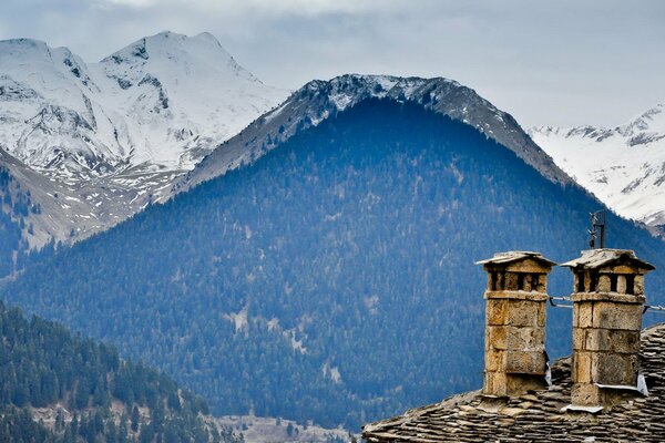 Houses on the background of blue mountains with snow caps