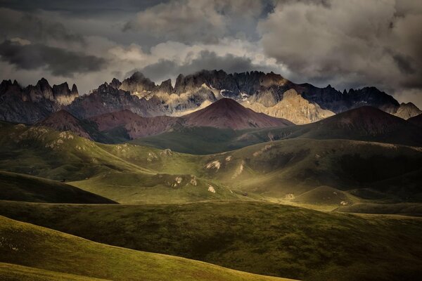 Landscape with a mountain range and hills. Cloudy sky with clouds