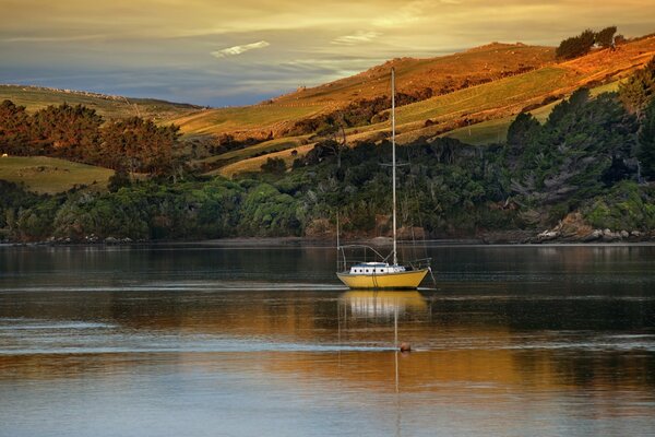 Bateau sur le lac. Collines et arbres