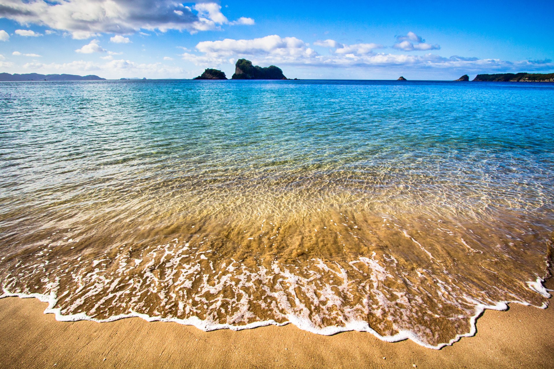 penisola di coromandel nuova zelanda cielo nuvole mare sabbia surf orizzonte roccia