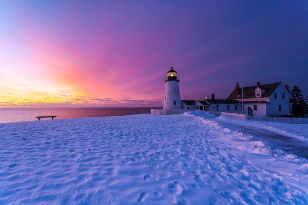 Hiver indescriptible en Angleterre du phare de Bristol, neige blanche, coucher de soleil, banc sur le rivage, traces de construction