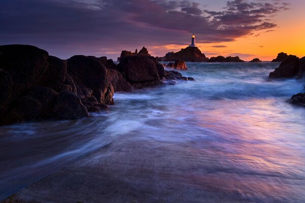 Crépuscule du coucher du soleil du soir avec vue sur le phare dans la mer