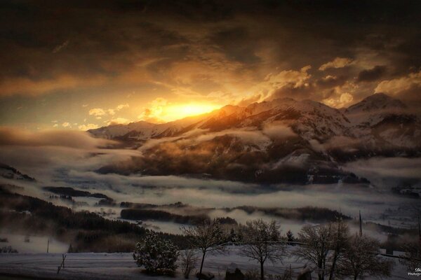 Blick auf den Sonnenuntergang von den Gipfeln der schneebedeckten Hügel