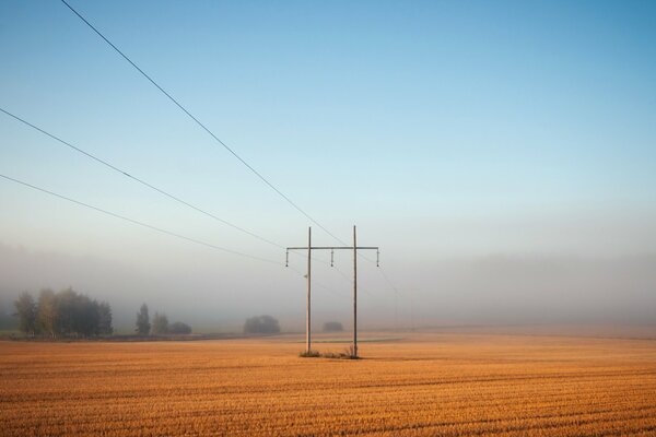 Krajobraz mglistego pola i linii energetycznych