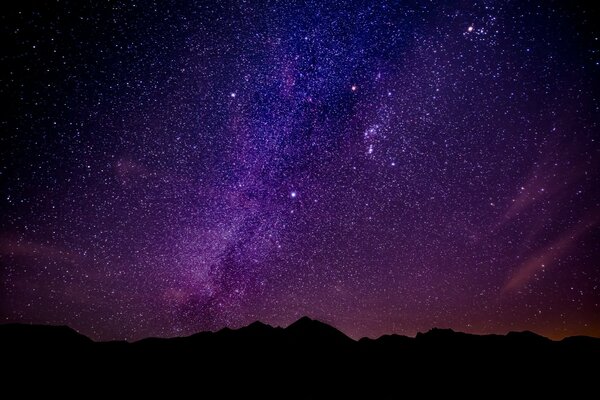 The Milky Way is visible in the night sky in the mountains