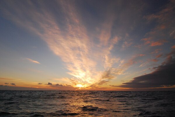 Amanecer en el mar con nubes flotantes