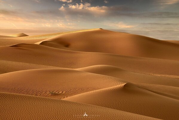 Sand dunes against a blue sky