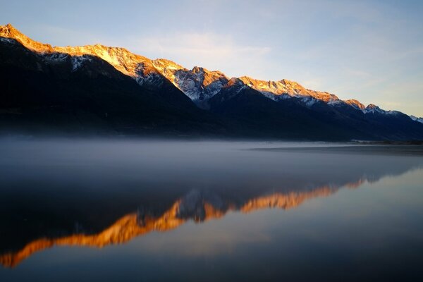 Górskie jezioro rano we mgle