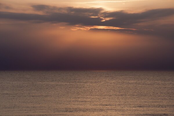 Sur l horizon de la mer, les rayons du soleil se frayent un chemin