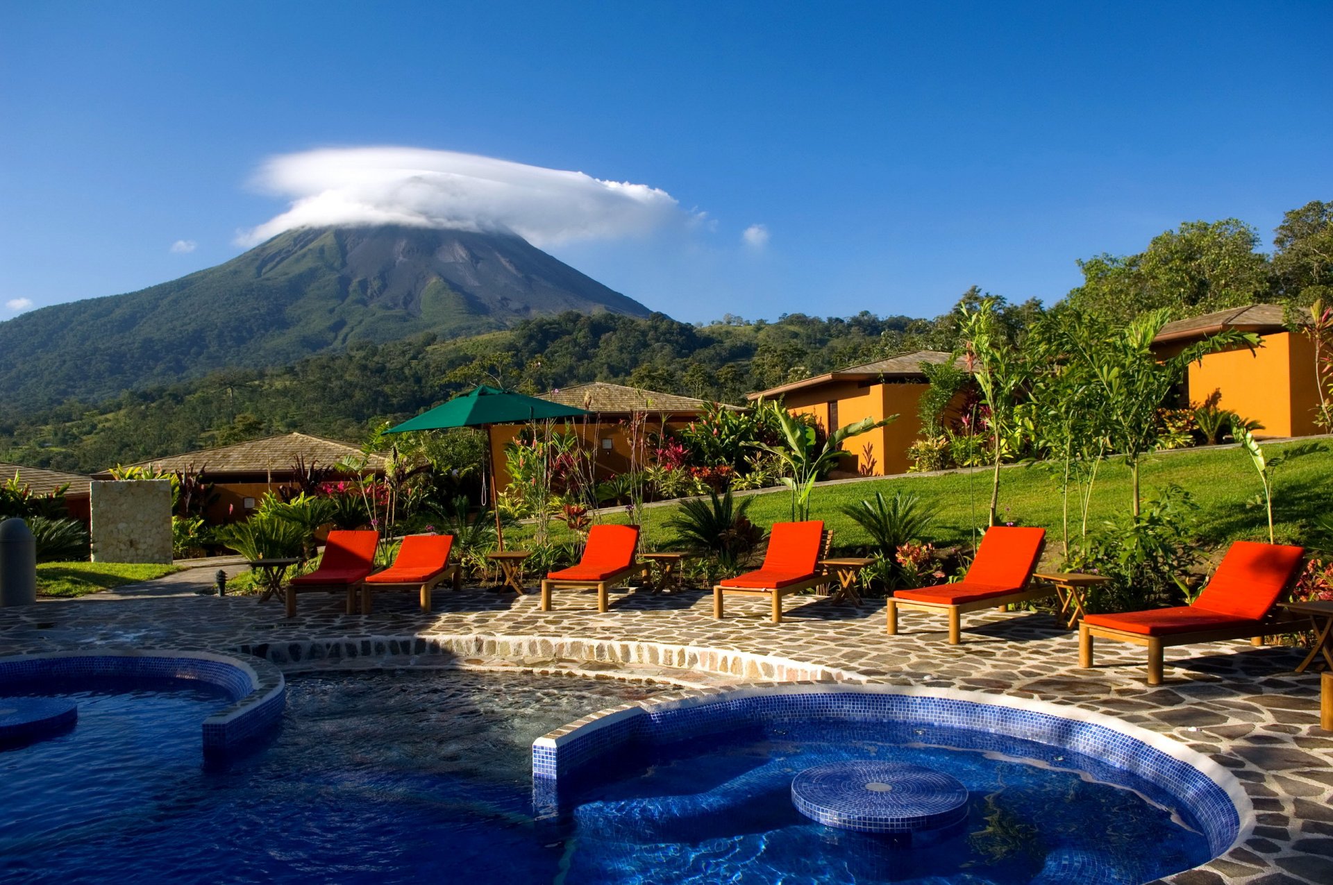 piscina montaña cielo nubes tumbonas cabañas