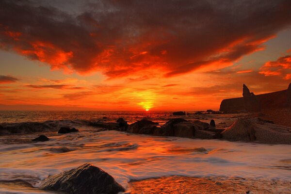 Crimson sunset over the sea. Sandy beach